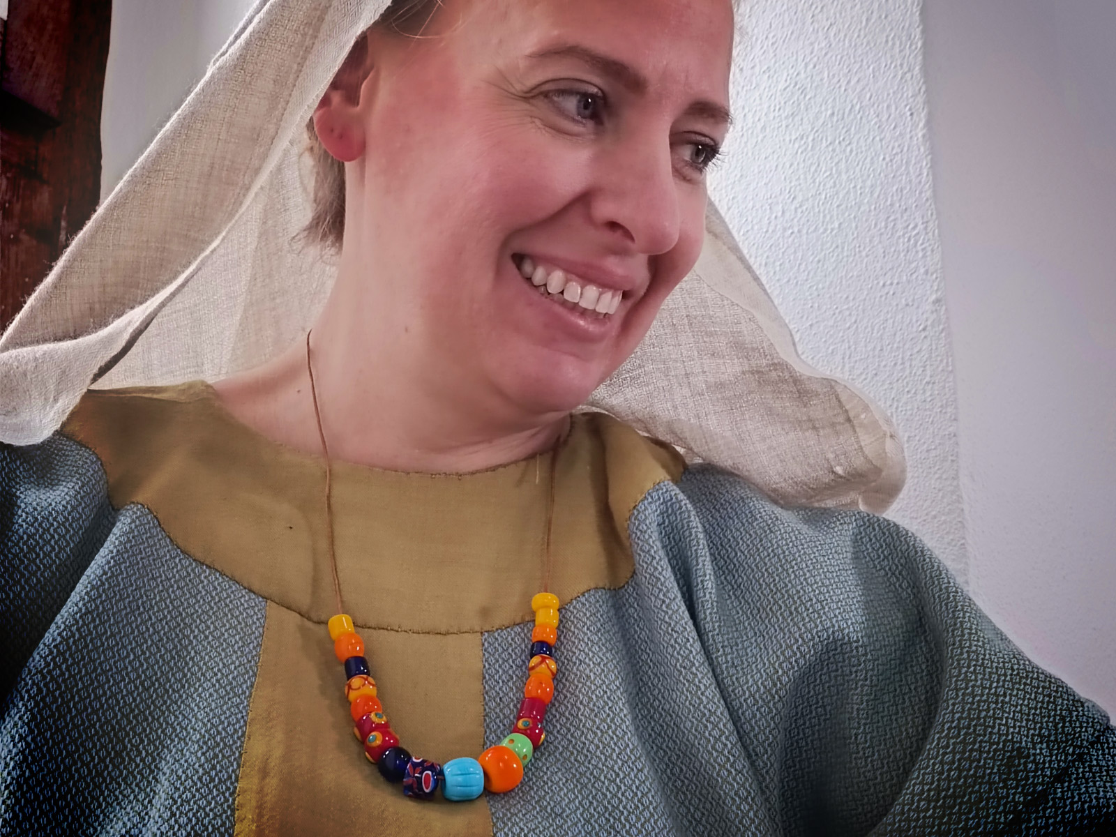 Frau im Gewand einer Saechson aus dem Mittelalter mit bunter Kette